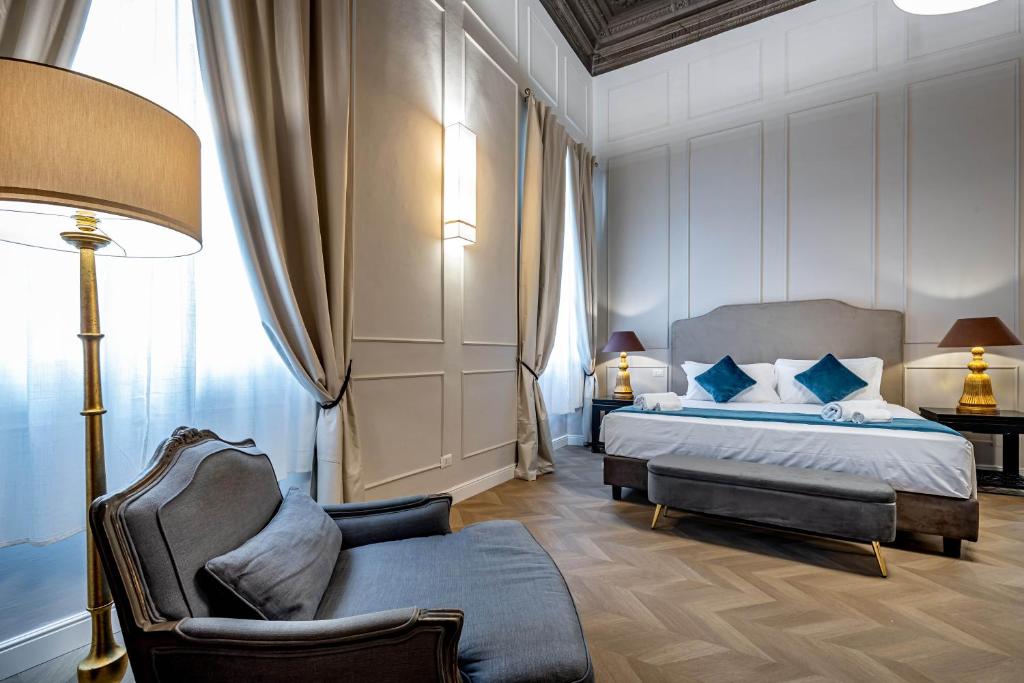 a bedroom with a bed and a chair and a lamp at Residenza d'epoca Poliziano in Florence
