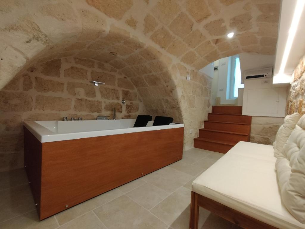 La salle de bains est pourvue d'un lavabo et d'un mur en pierre. dans l'établissement Casa Perricci - short lets - Monopoli (BA), à Monopoli