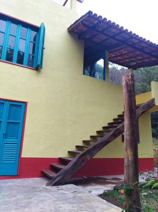 アイウルオカにあるCasa do Bosqueの青い扉の横に階段がある建物