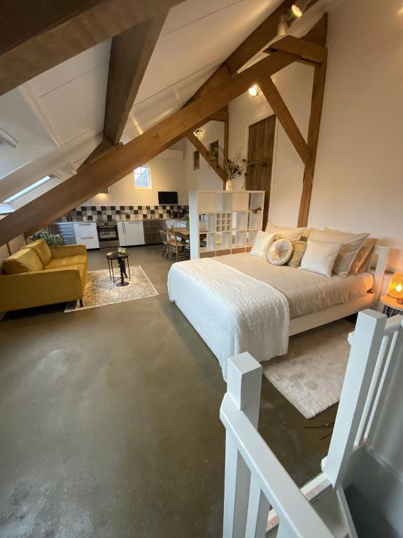um quarto com uma cama grande num sótão em B&B / Studio De Rozeboom em Steenbergen
