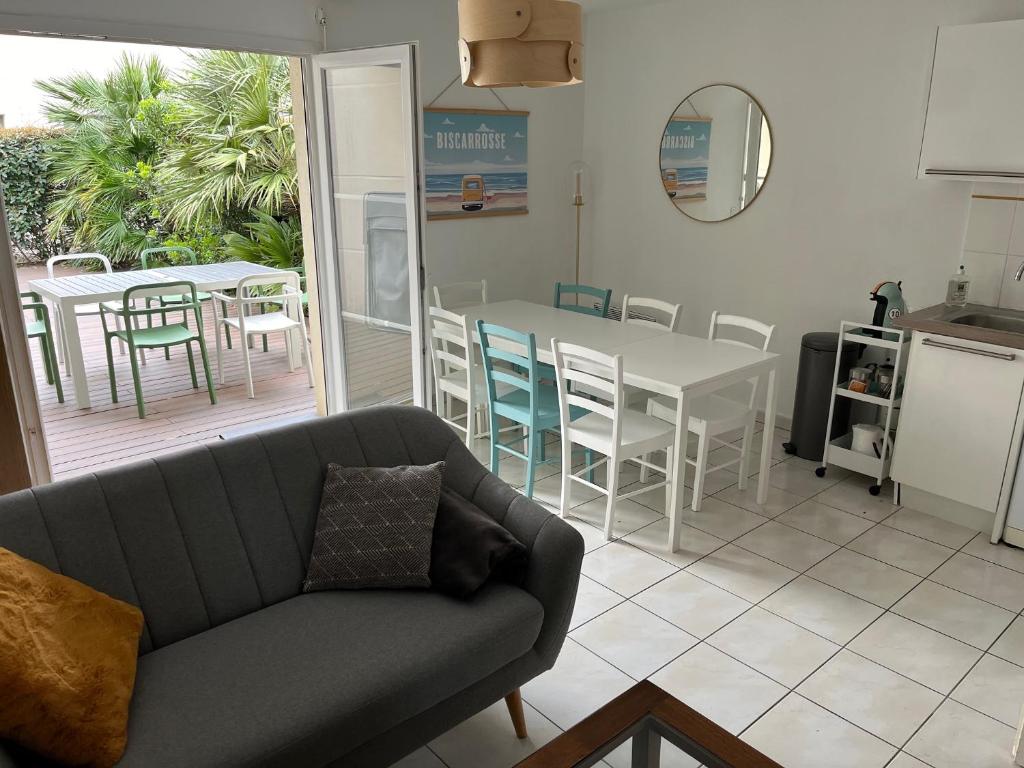 - un salon avec un canapé, une table et des chaises dans l'établissement Bisca'House - Maison dans résidence, à Biscarrosse-Plage