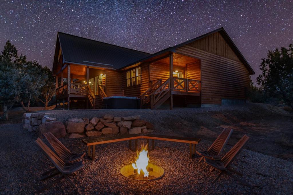 una cabaña de madera con una hoguera frente a ella por la noche en Moonlight Lodge, luxury home, Zion and Bryce, en Orderville