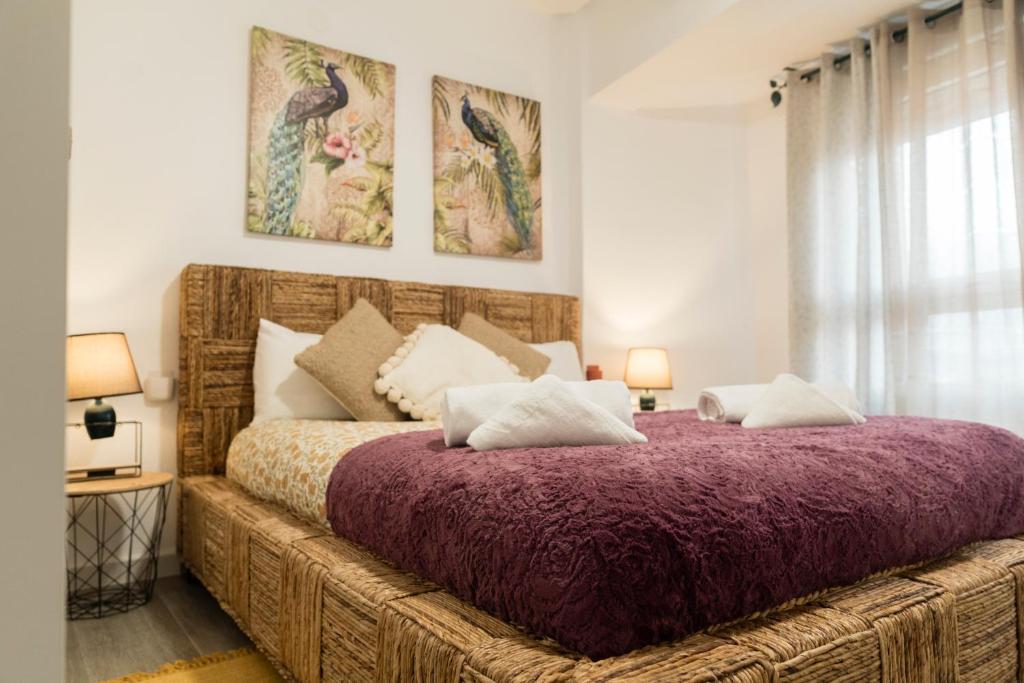 1 dormitorio con 1 cama grande con manta morada en Apartamento El oso y el Madroño, en Villena