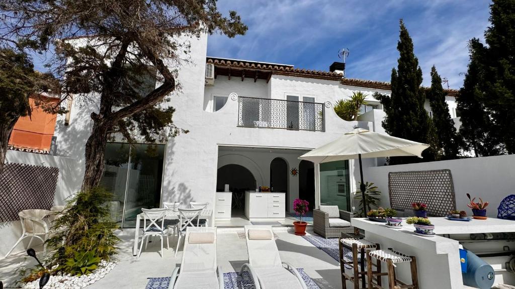 een patio met een tafel en stoelen en een parasol bij Casa Blu Marbella in Marbella