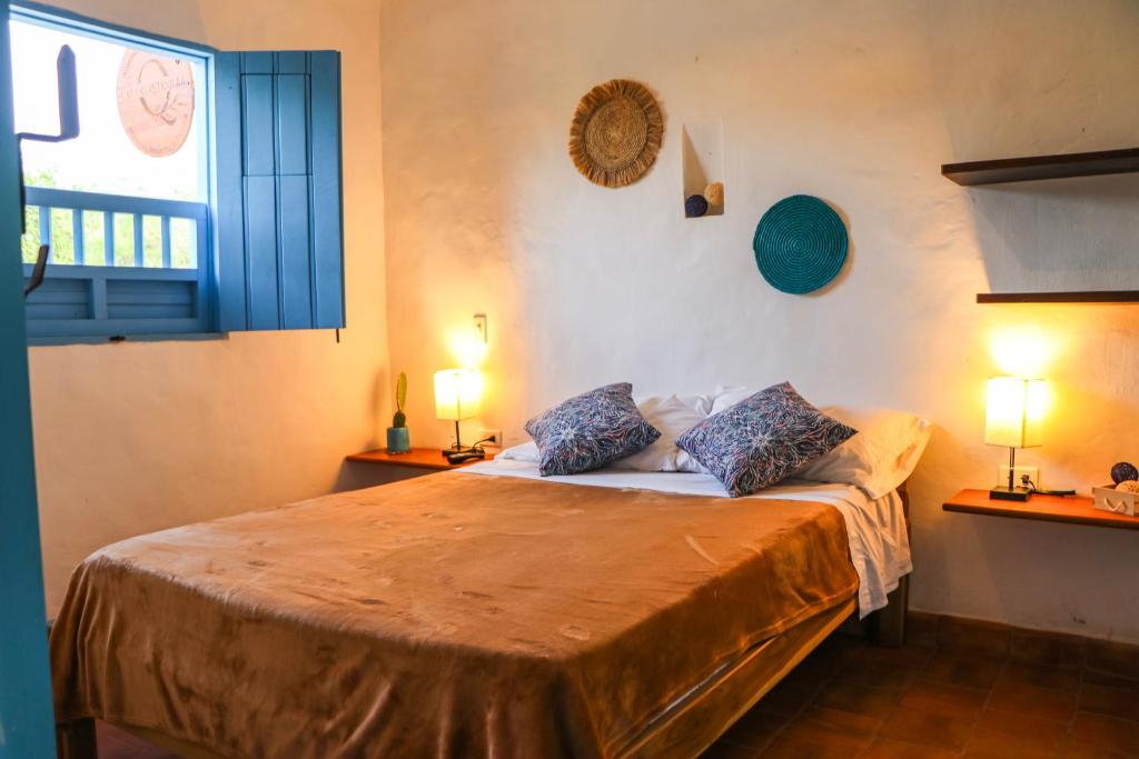 1 dormitorio con 1 cama con 2 lámparas y una ventana en Casa Quintanilla Barichara, en Barichara