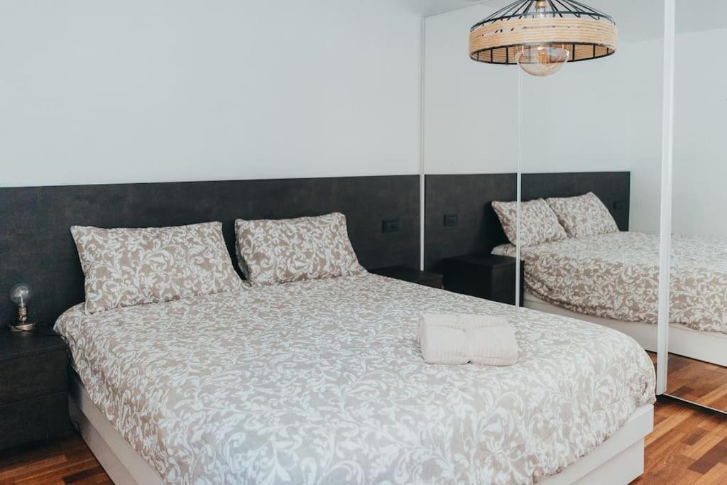 a bedroom with two beds with white comforter at Tra monte e lago in Terlago