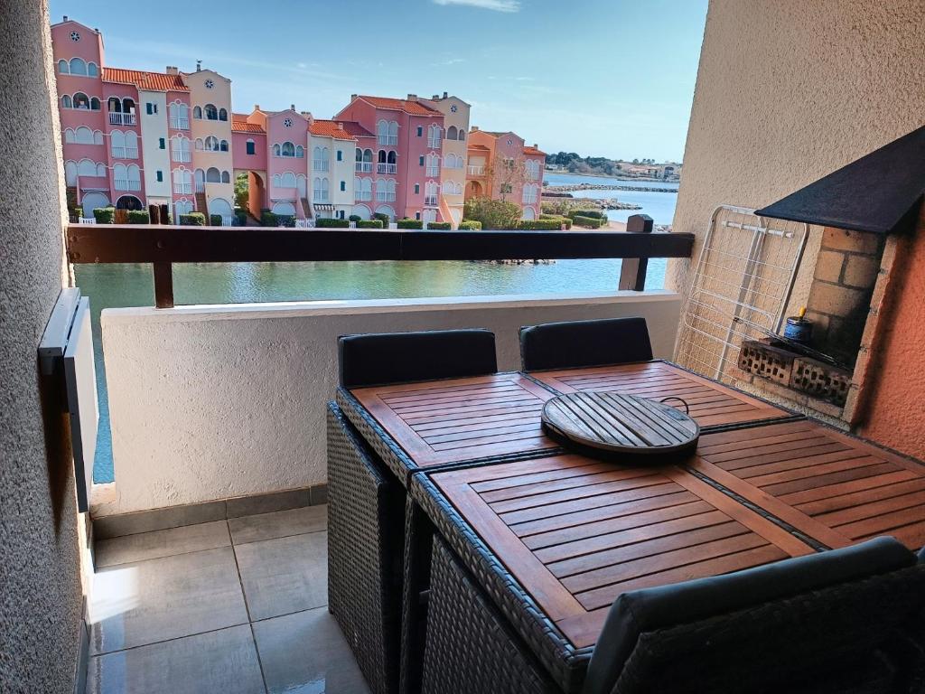 a table on a balcony with a view of the water at Chez Fifi au Barcarès in Le Barcarès