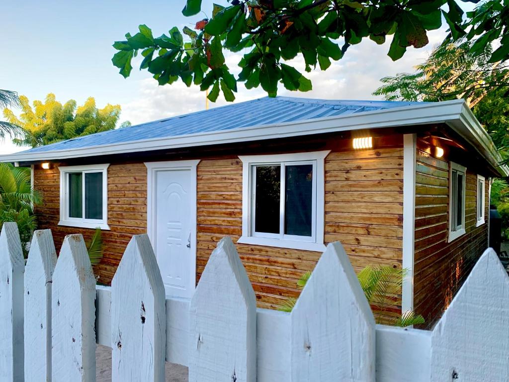 una pequeña casa de madera con una valla blanca en Fisherman house on a paradise island, en La Romana