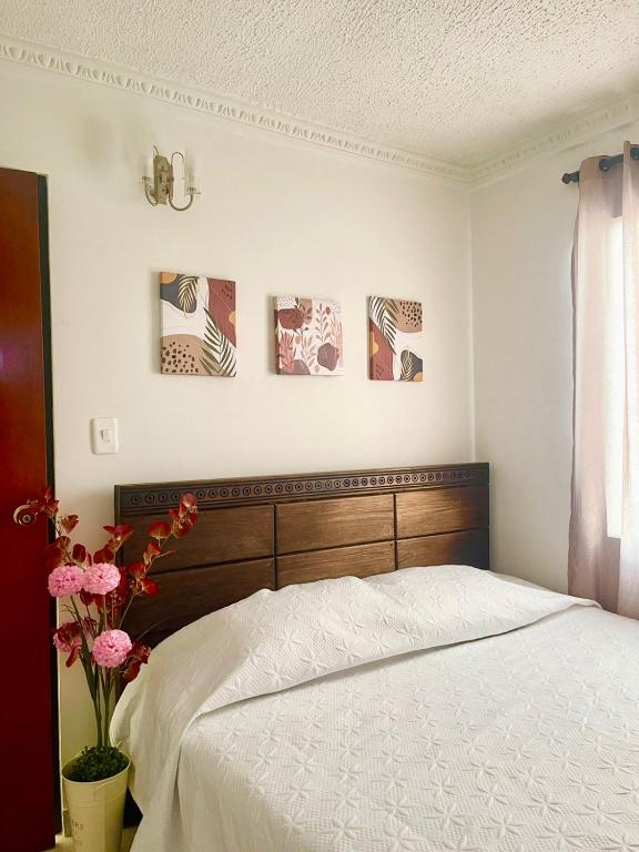 1 dormitorio con 1 cama y 3 cuadros en la pared en Apartamento para máx 5 personas, habitación privada con cama doble , habitación abierta con camarote y sofá cama, comodo, bonito, central, bien ubicado, en el centro de palmira en Palmira