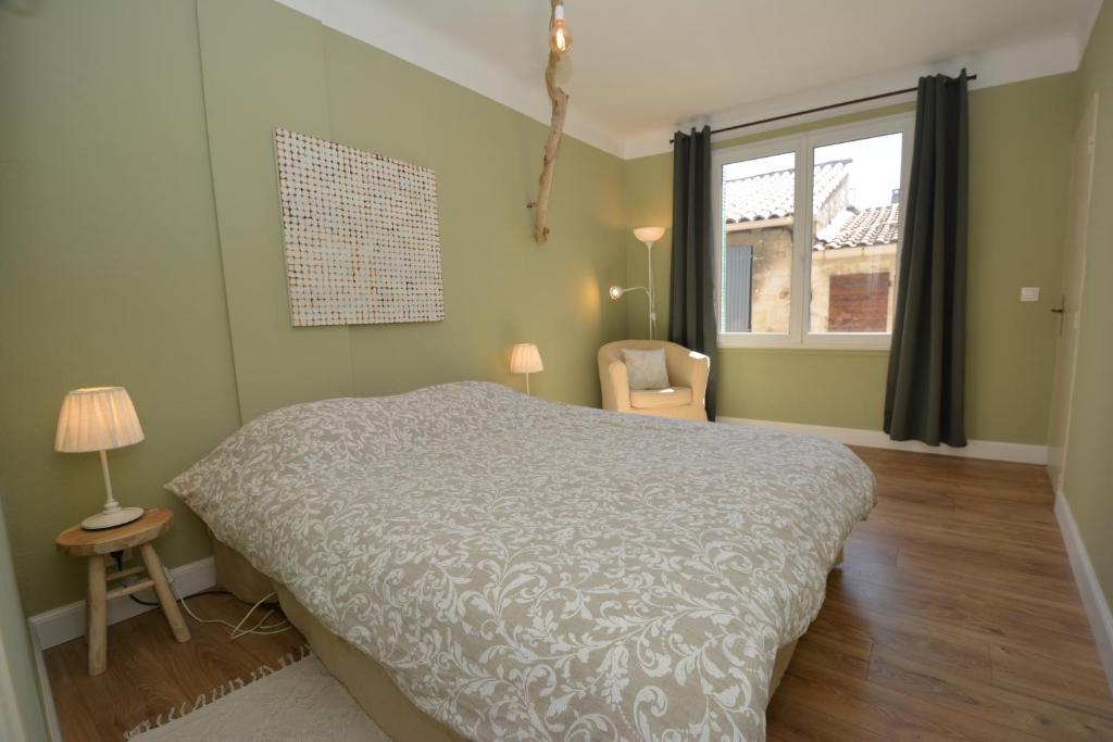 um quarto com uma cama, uma cadeira e uma janela em Maison Le Petit Balcon Beaucaire em Beaucaire