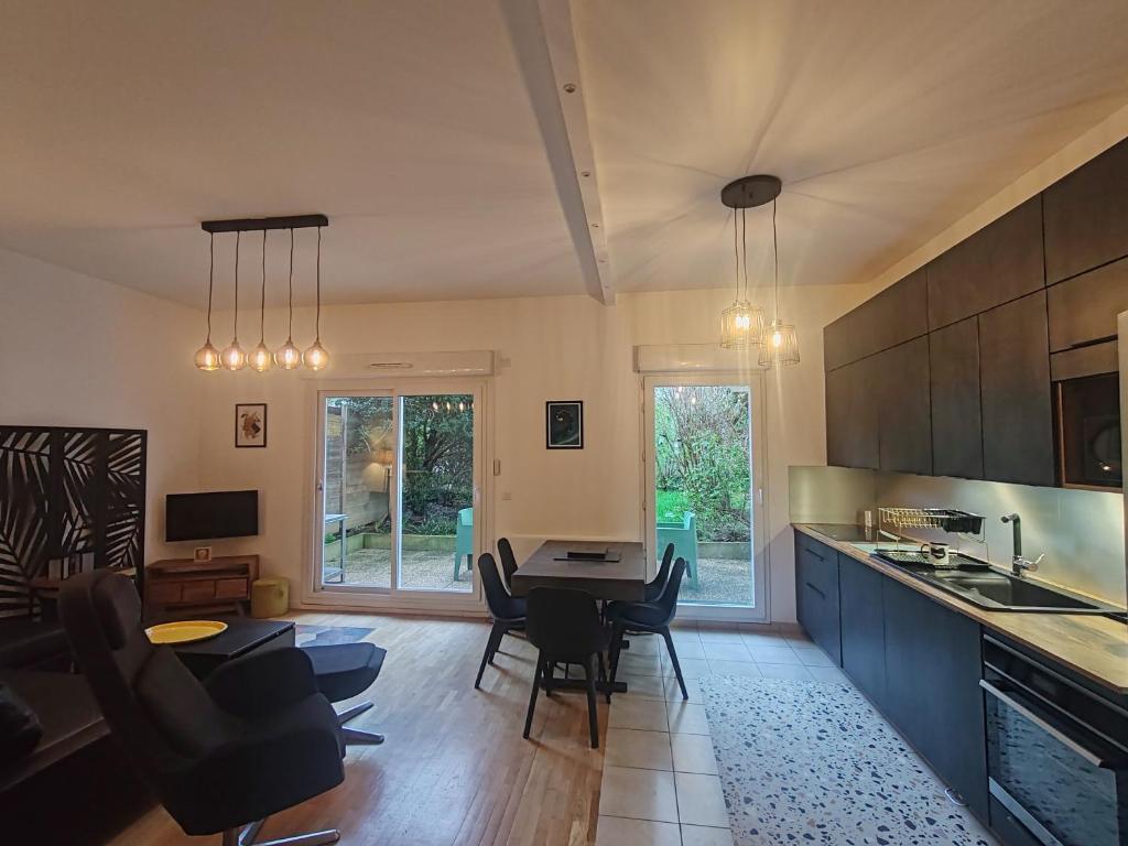 a kitchen and dining room with a table and chairs at LONG STAY Courbevoie charmant Apt T3 avec jardin et terrasse, calme, proche transports in Courbevoie