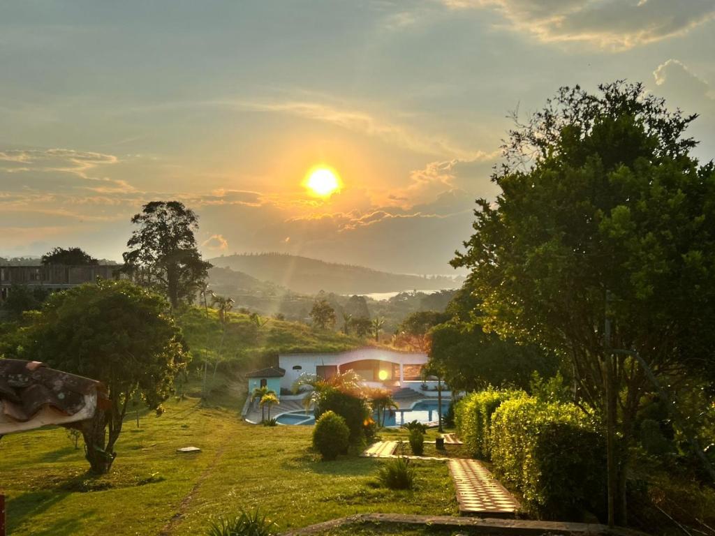 a view of a house with the sunset in the background at Finca Calimita in Calima