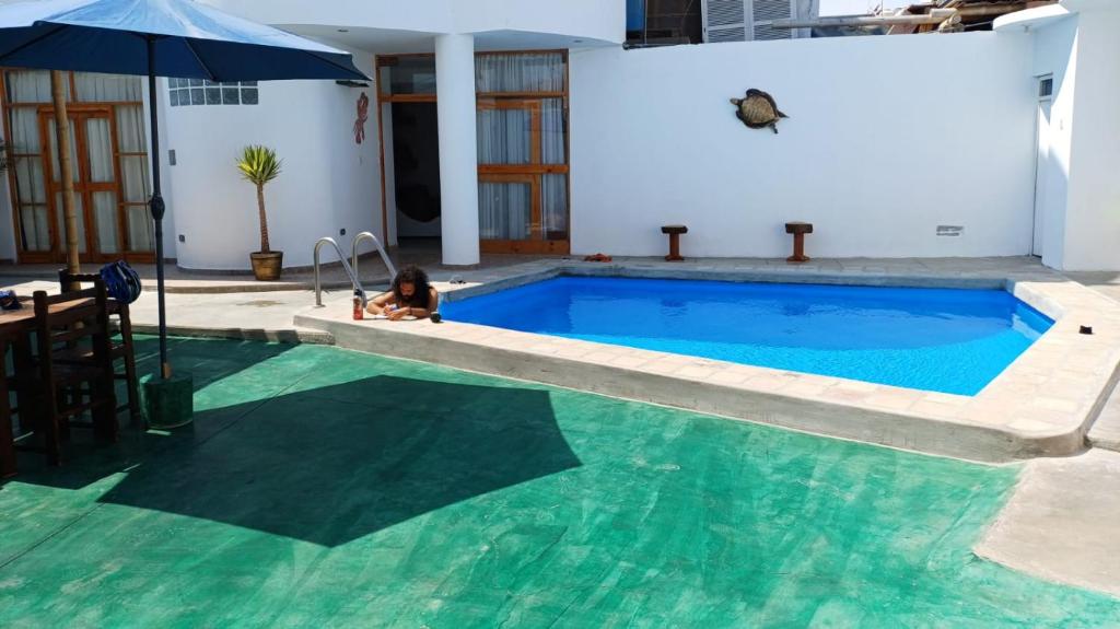 a woman sitting on a swing in a swimming pool at El Capricho II Paracas in Paracas