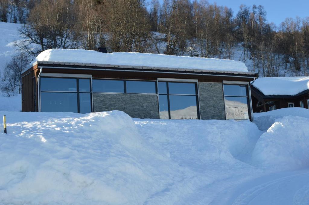 un edificio cubierto de nieve con un montón de nieve en Pow Panorama - High standard Mountain home en Sogndal