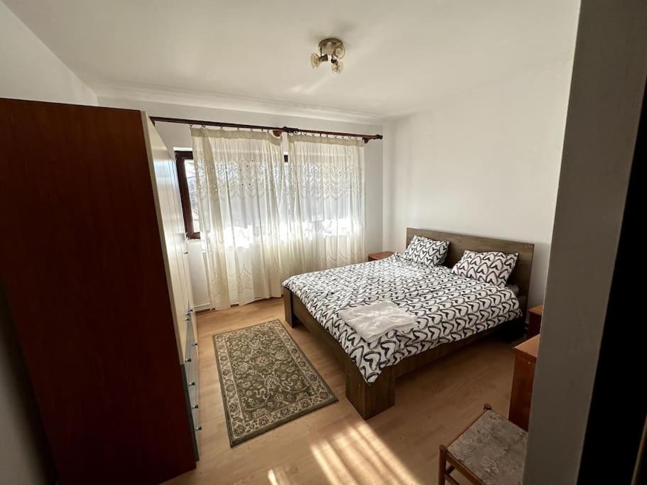 a small bedroom with a bed and a window at Căsuța de la țară in Bradu