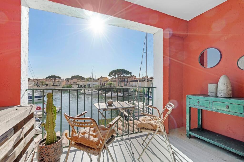 a balcony with chairs and a table and a window at My little Port Grimaud in Grimaud