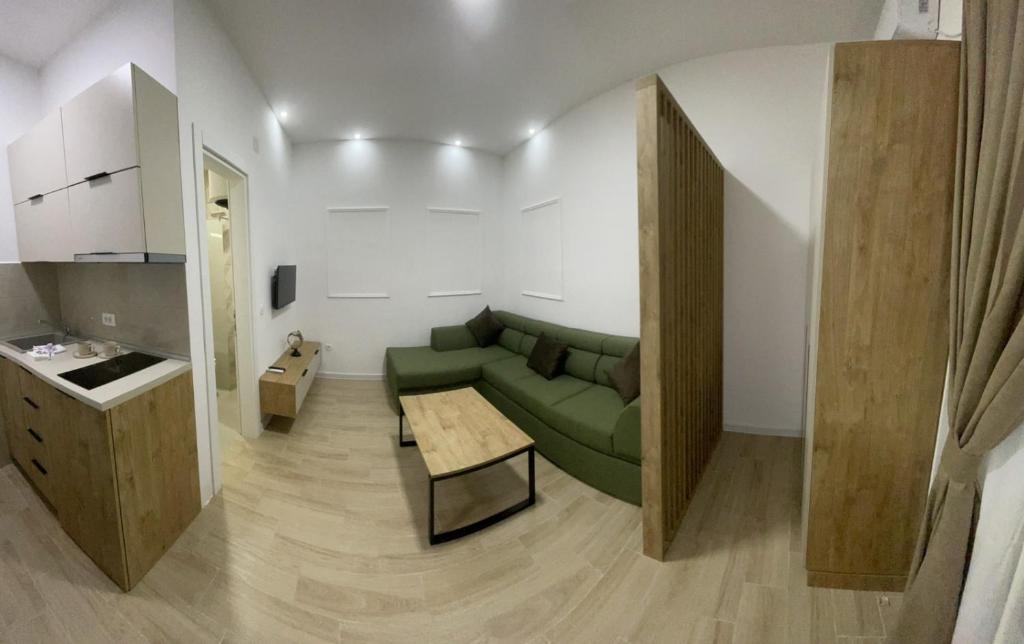un salon avec un canapé vert et une table dans l'établissement Apartments KinGs, à Petrovac na Moru