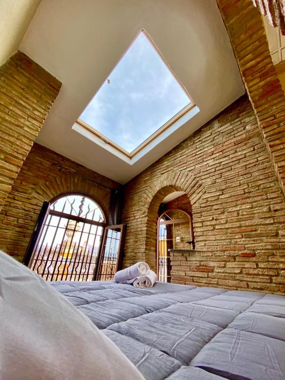 a bedroom with a large bed with a large window at Apartamentos Abeto in Ronda