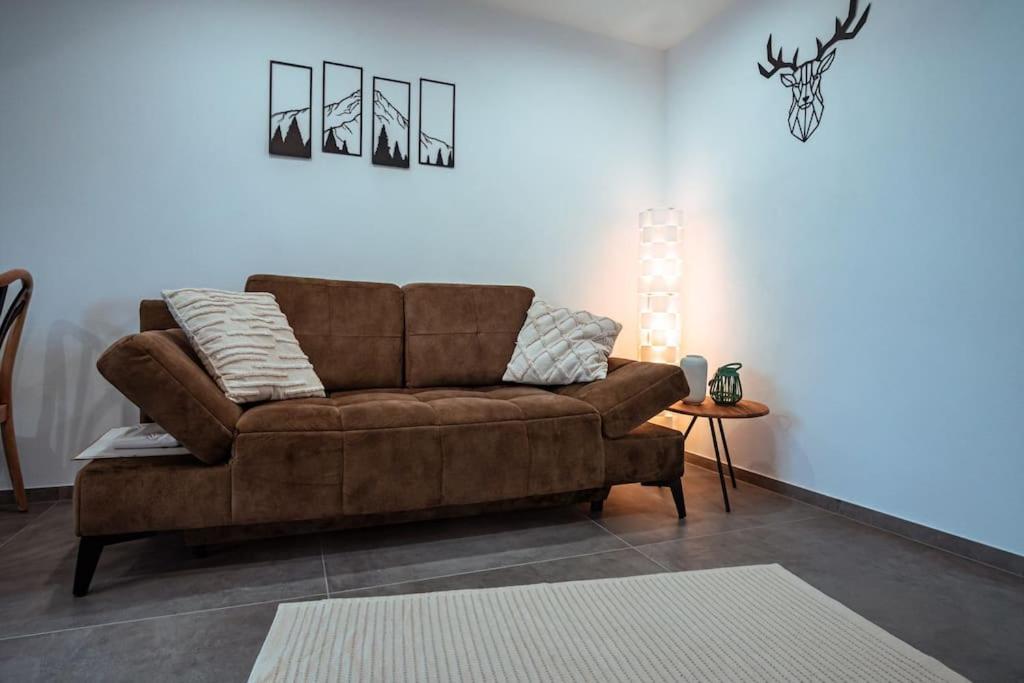 a living room with a brown couch and a table at Neue Fewo mit Schlossblick - Urlaub im Wein- und Ferienort Bekond in Bekond