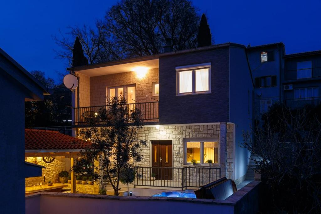 une maison la nuit avec les lumières allumées dans l'établissement House Roko, à Dramalj