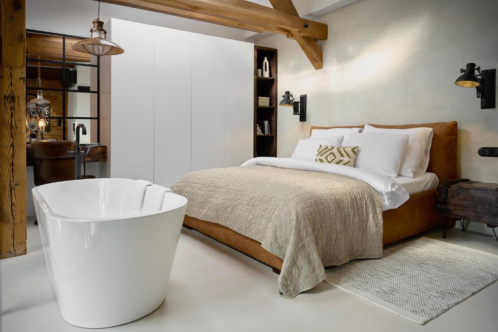 a bedroom with a large bed and a bath tub at Loft 16 in Iława