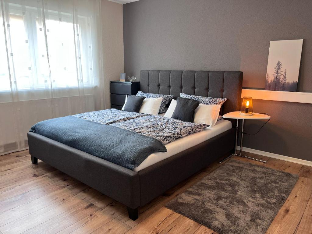 een slaapkamer met een groot bed en een blauwe deken bij Gemütlicher Bungalow in Stadtnähe in Aschaffenburg