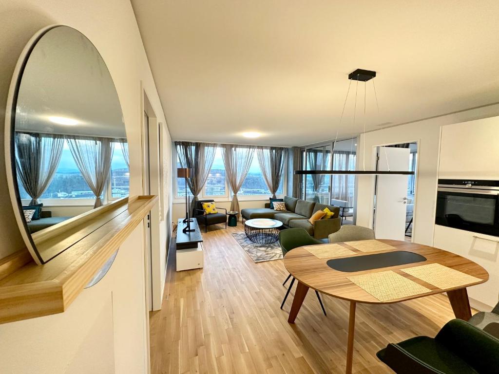 3.5Room@MydiHei Apartments في نيوهاسن ام رينفا: غرفة معيشة مفتوحة مع طاولة وغرفة معيشة