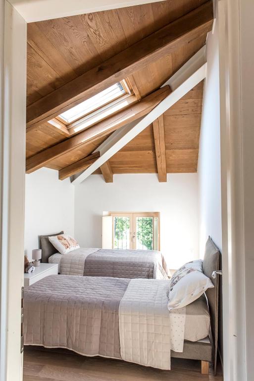 Seconda camera con due letti singoli e soffitto in legno