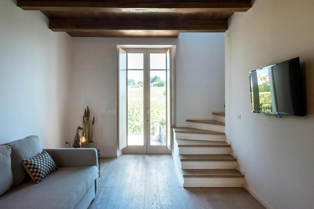Soggiorno del loft a Sirolo con divano, scala interna e televisore