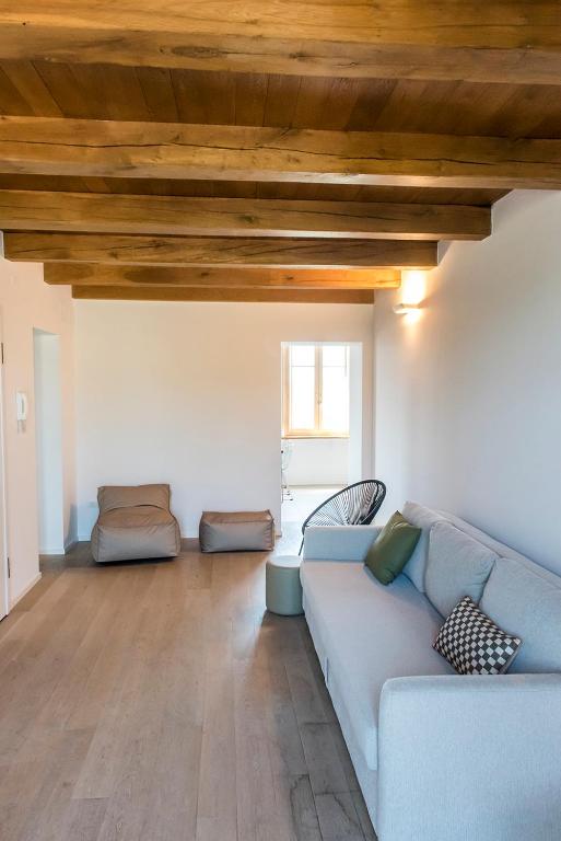 Salotto con divano blu e travi in legno del Conero Loft 21