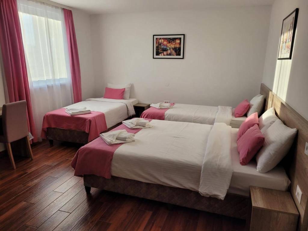 una camera d'albergo con due letti e una finestra di Dona, Altina a Belgrado