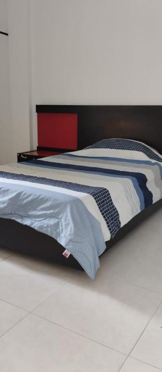 una camera con un letto con un piumone nero e blu di HOSTAL CARACOLI - HUECO a Valledupar