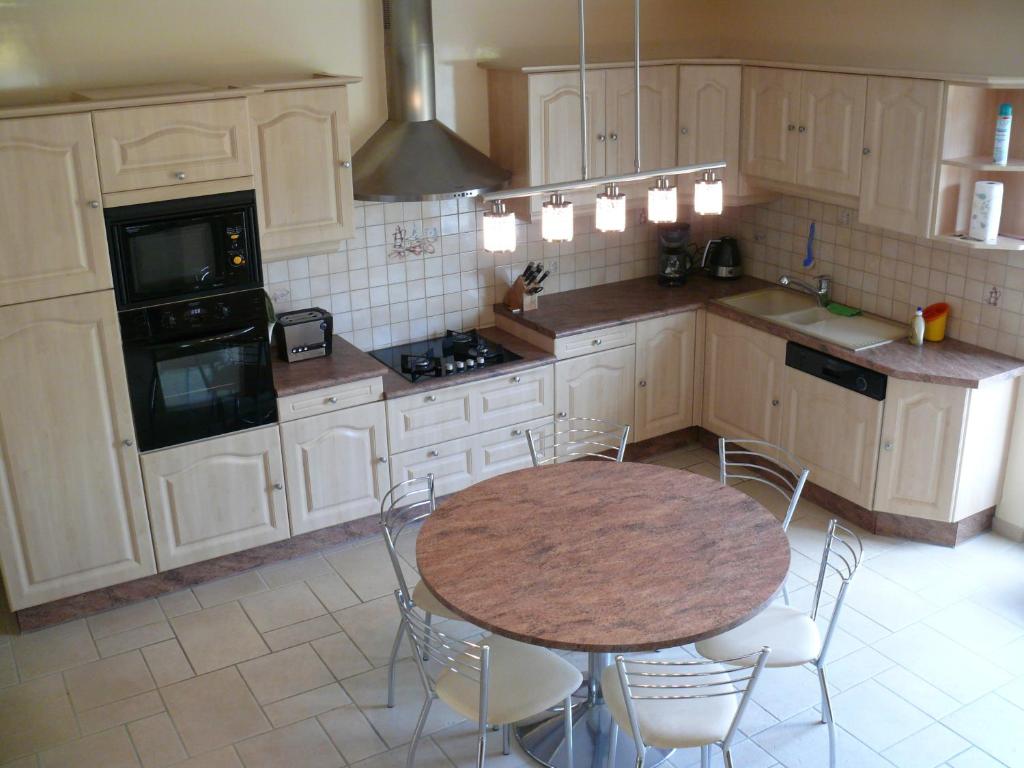 a kitchen with a table and chairs in it at Gîte De L&#39;Etot Fossey in Marchésieux