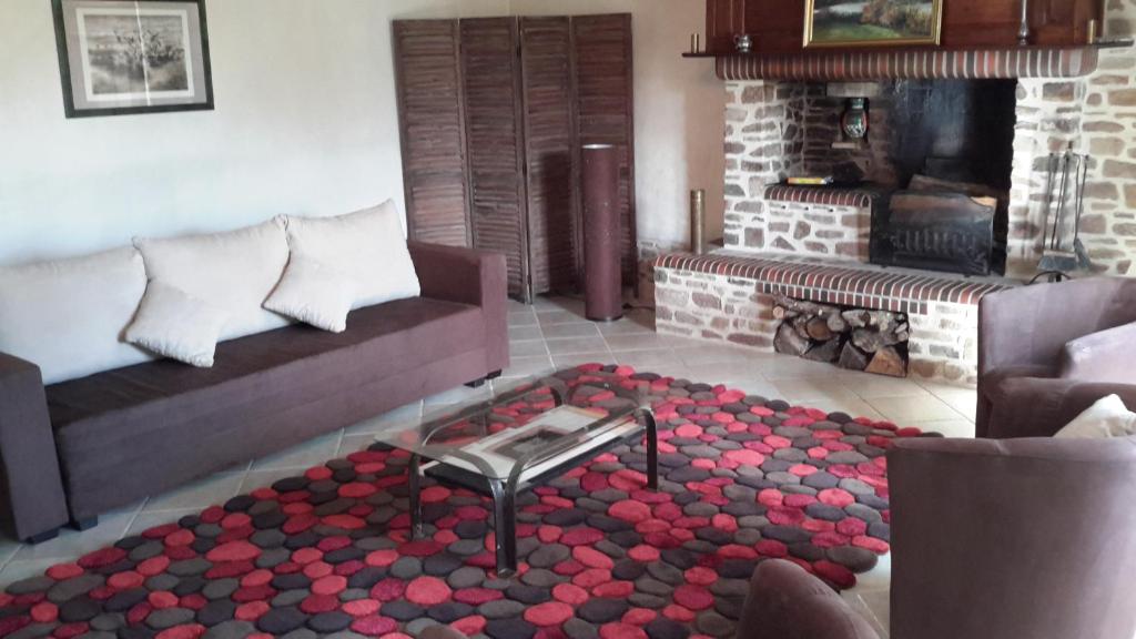 a living room with a couch and a fireplace at Gîte De L&#39;Etot Fossey in Marchésieux