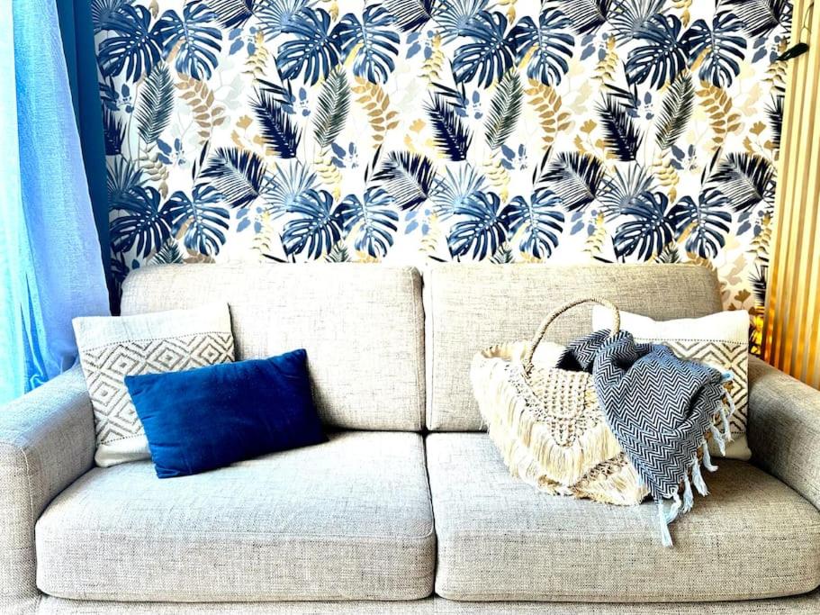 d'un canapé avec du papier peint bleu et blanc. dans l'établissement *La Brise Marine*Piscine*Parking*Clim*, au Grau-du-Roi