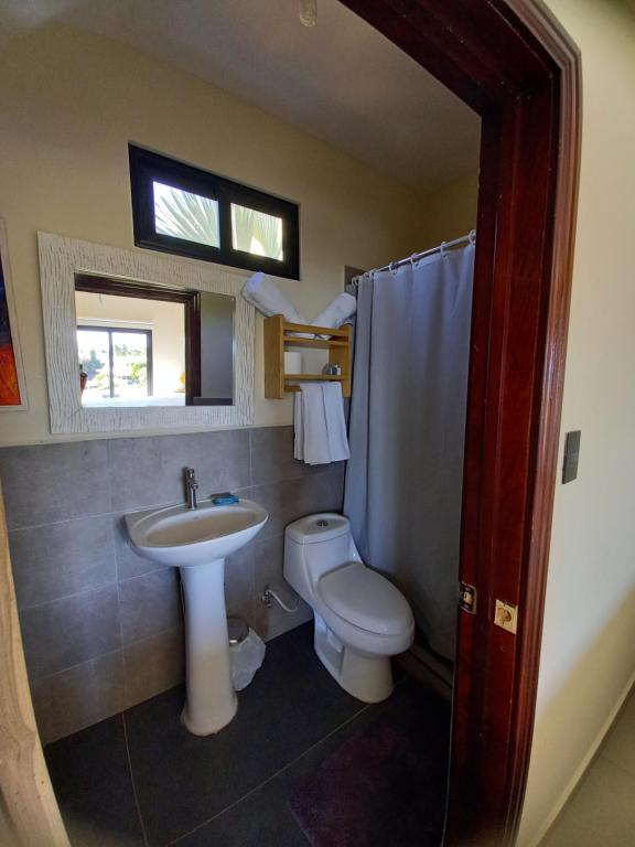 a bathroom with a sink and a toilet and a window at Kuluka Resort And Spa in San Miguel