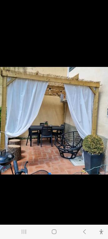 a pavilion with a table and chairs with curtains at La coccinella in Castelfiorentino