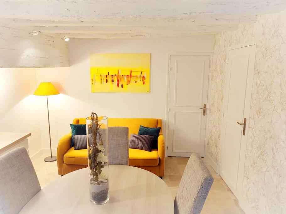 a living room with a table and a yellow couch at Cosy Claudel in Nogent-sur-Seine