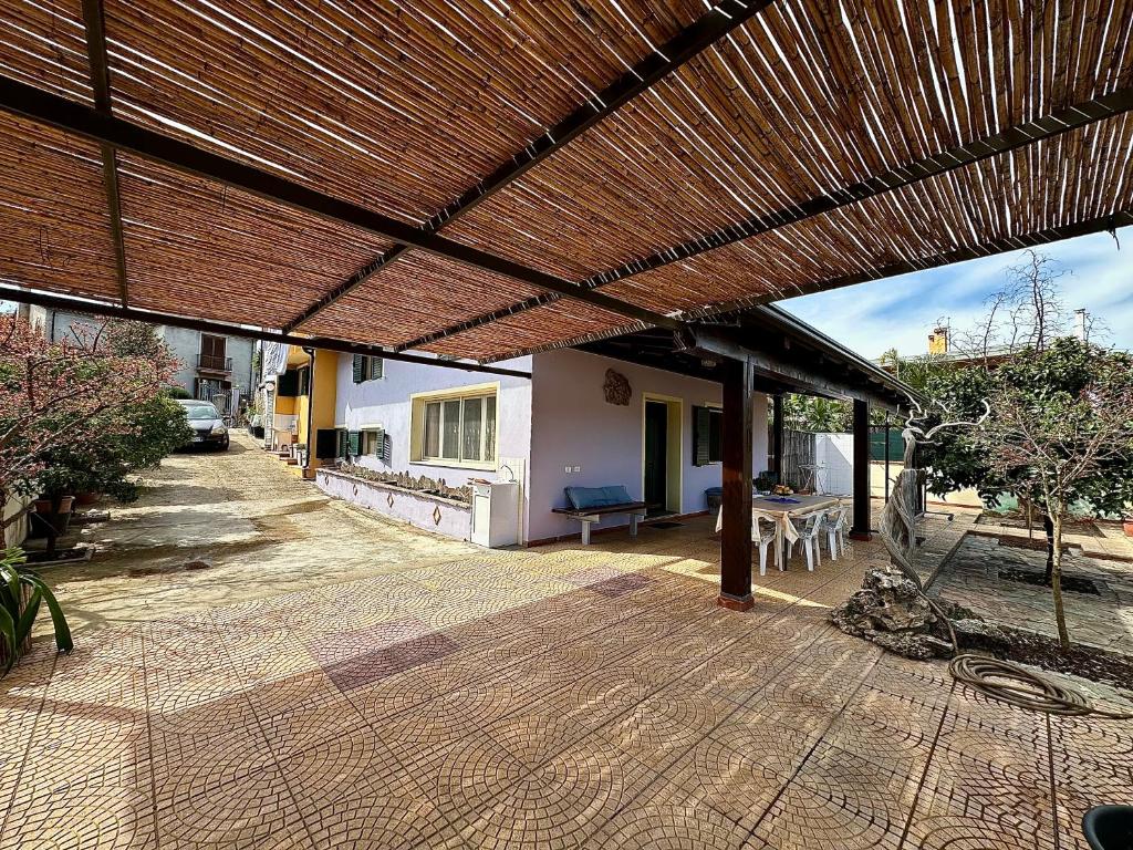 a patio with a wooden deck with a roof at La Bomboniera in Bari Sardo