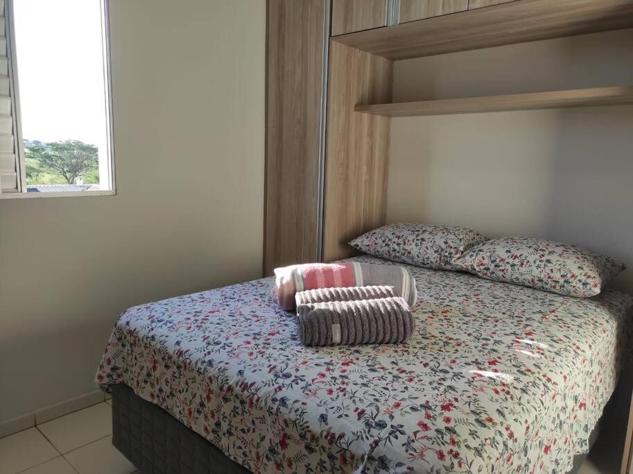 a bedroom with a bed with two pillows on it at Apartamento inteiro no Bairro Alto Umuarama in Uberlândia