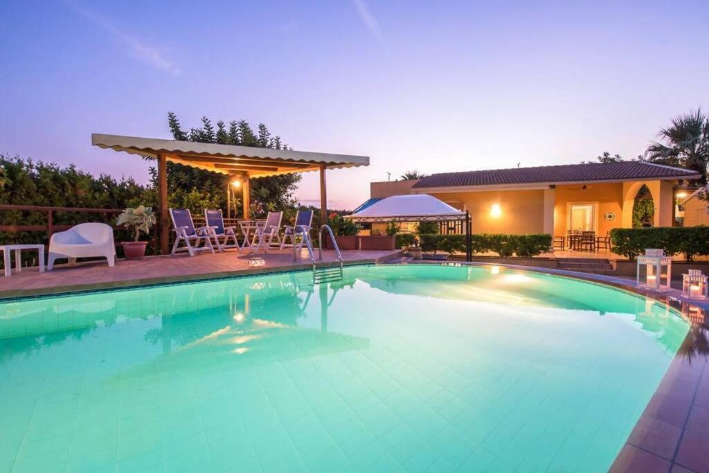 a swimming pool with chairs and a house at Villa Candiano in Sampieri