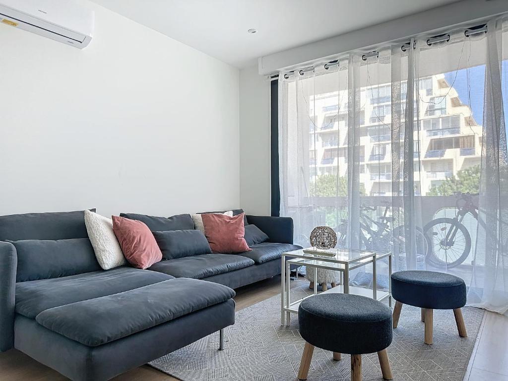 un salon avec un canapé bleu et une table dans l'établissement Appartement spacieux 2 chambres proche mer, à La Grande Motte