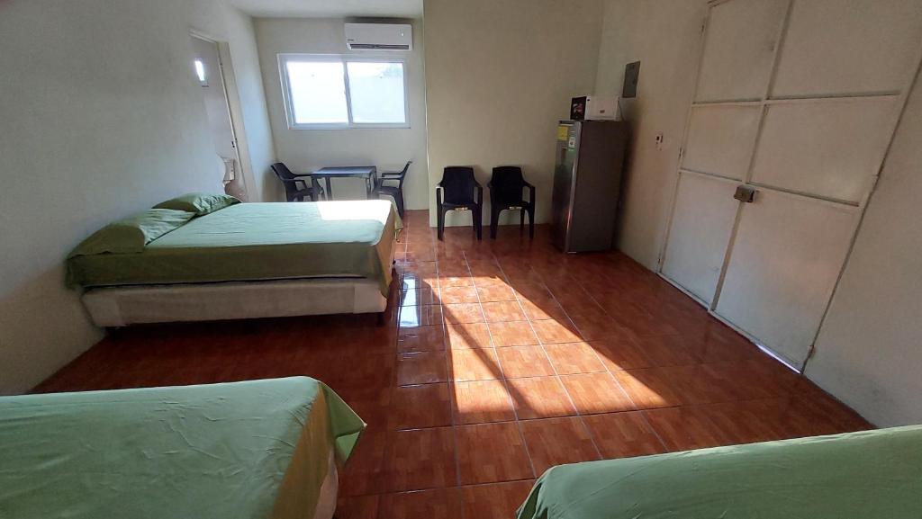 a room with two beds and a table and chairs at Villa Santos in Escuintla