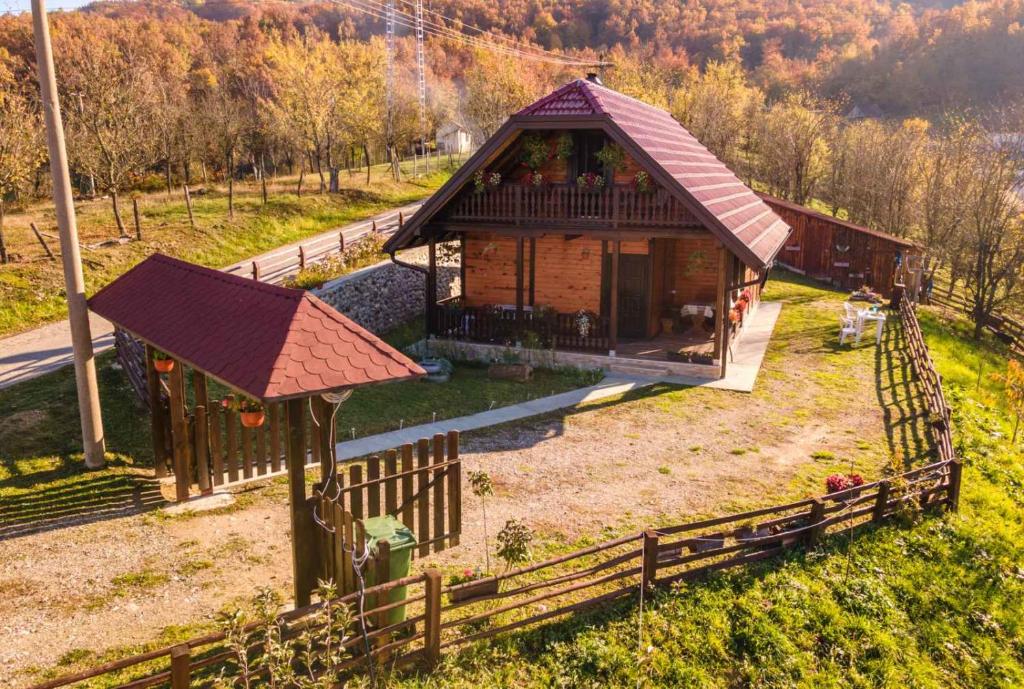 une petite maison dans un champ avec une clôture dans l'établissement Brvnara Sofiana, à Bajina Bašta