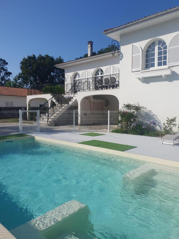 une maison avec une piscine devant dans l'établissement Villa Blanche spacieuse pour 8 (modulable), avec mer, piscine, balades à vélo, à La Tremblade