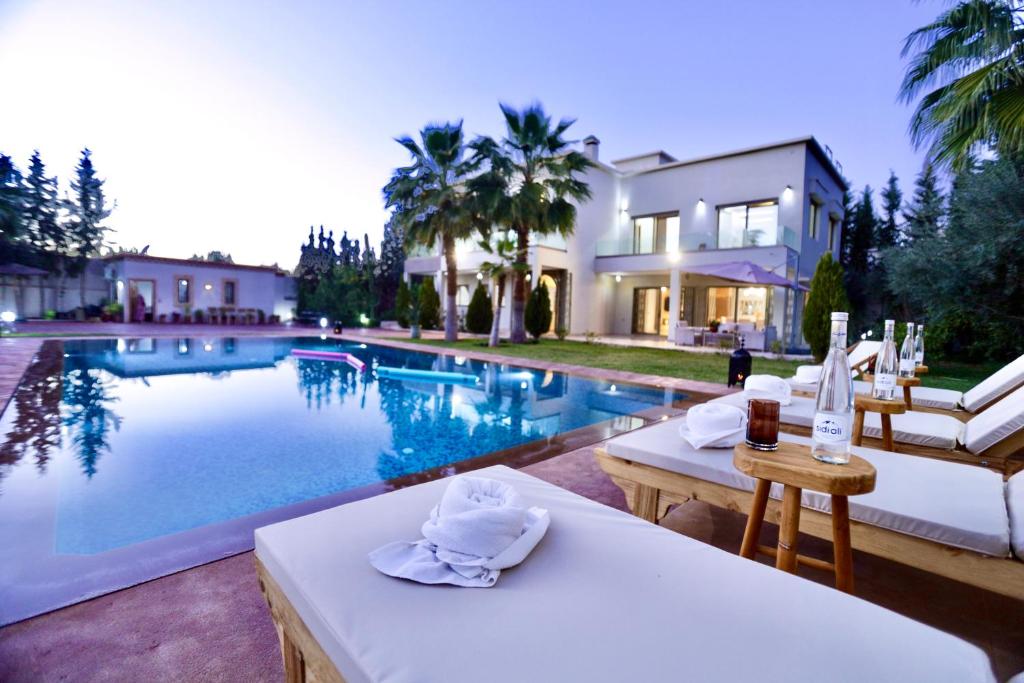 馬拉喀什的住宿－*Villa de luxe à Marrakech, vue sur les montagnes*，别墅前设有游泳池