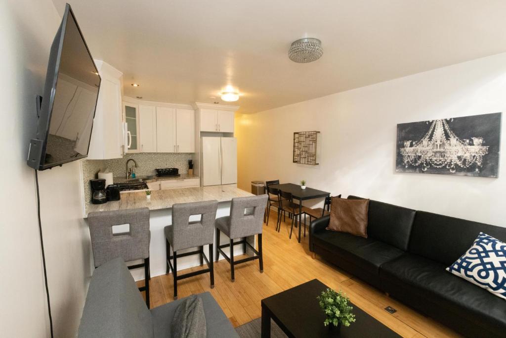 a living room with a couch and a kitchen at Charming 2-Bed Apt Mins from NYC - Sleeps 7 in Union City