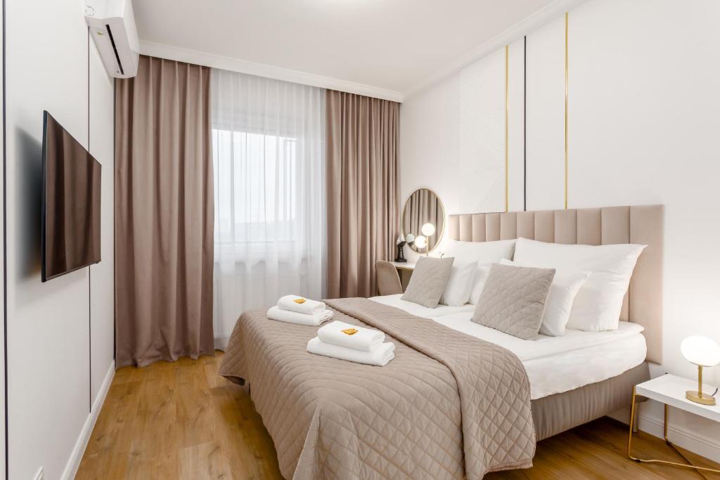 sypialnia z dużym łóżkiem z dwoma ręcznikami w obiekcie Warsaw View Prestige Apartment w Warszawie