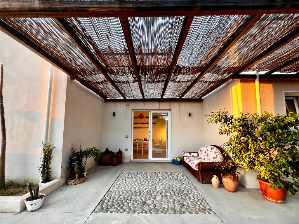un patio al aire libre con techo de madera y sofá en Casa Cunaci Bed and Breakfast, en Capo Vaticano