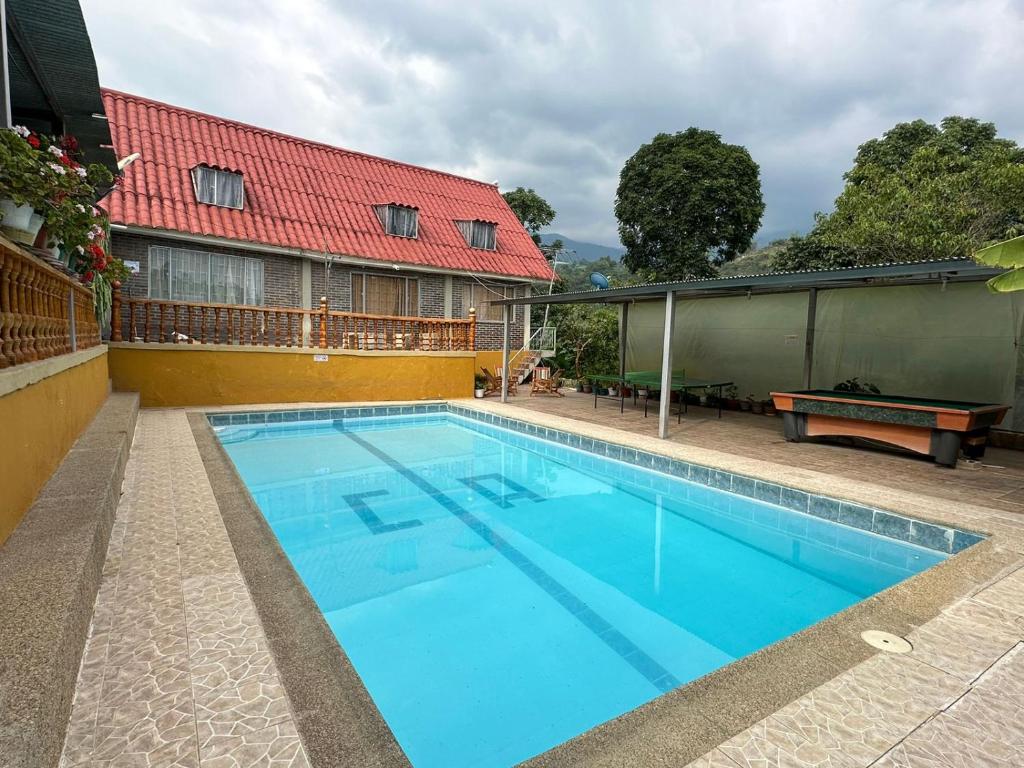 a large blue swimming pool next to a building at Finca Santa Lucia, Anolaima in Anolaima